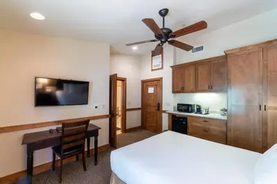 a bedroom with a bed and a desk and a ceiling fan at Granlibakken Tahoe in Tahoe City