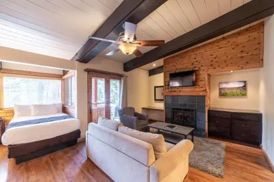 a bedroom with a bed and a couch and a fireplace at Granlibakken Tahoe in Tahoe City
