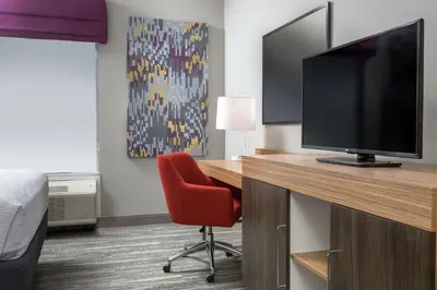 a room with a desk with a television and a red chair at Hampton Inn & Suites Reno/Sparks in Reno
