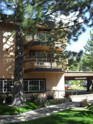 a building with a balcony and a tree at The Tahoe Beach & Ski Club Owners Association in South Lake Tahoe