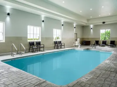 a swimming pool in a hotel with chairs and tables at Holiday Inn Express Lodi by IHG in Lodi