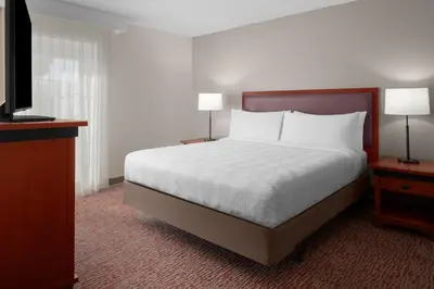 a bedroom with a bed and two lamps and a television at Larkspur Landing Extended Stay Suites Roseville in Roseville