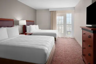 a hotel room with two beds and a flat screen tv at Larkspur Landing Extended Stay Suites Folsom in Folsom