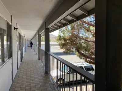 a balcony with a car parked on a street at Exchange Club Motel in Beatty