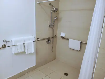 a bathroom with a shower with white towels at Exchange Club Motel in Beatty