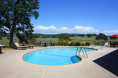 a large swimming pool with a picnic table and chairs at Oak Ridge Inn in Plymouth