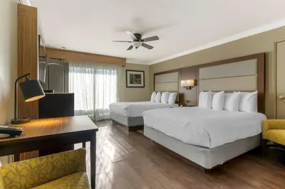 a hotel room with two beds and a desk at Best Western Plus Forest Park Inn in Gilroy