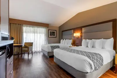 a hotel room with two beds and a desk at Best Western Plus Forest Park Inn in Gilroy