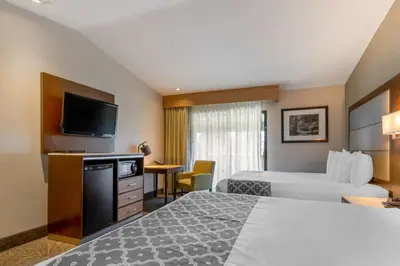 a hotel room with two beds and a flat screen tv at Best Western Plus Forest Park Inn in Gilroy