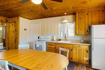 a kitchen with a wooden table and a white refrigerator at Cozy Seclusion in South Lake Tahoe