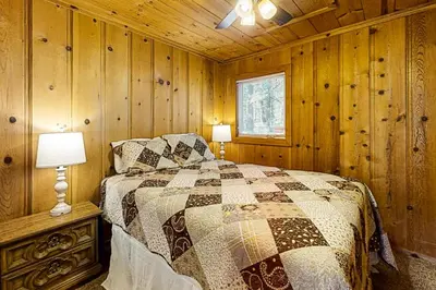 a bedroom with a bed in a wooden cabin at Cozy Seclusion in South Lake Tahoe