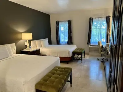 a hotel room with two beds and a chair at Rocklin Park Hotel, Trademark Collection by Wyndham in Rocklin