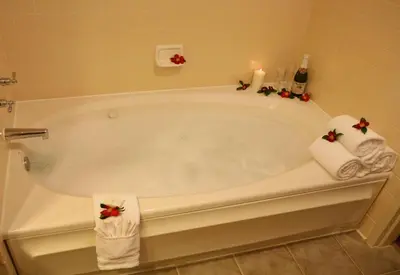 a bathroom with a bath tub with towels on it at Rocklin Park Hotel, Trademark Collection by Wyndham in Rocklin