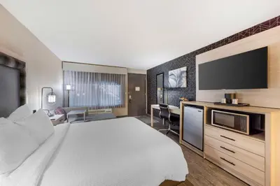 a hotel room with a bed and a flat screen tv at Aiden by Best Western South Reno in Reno