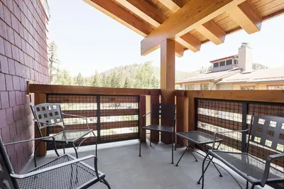 a balcony with chairs and tables and a wooden roof at Village 1401 in Mammoth Lakes