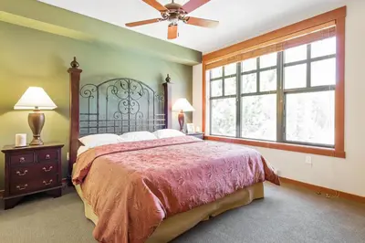 a bedroom with a large bed and a large window at Village 1401 in Mammoth Lakes