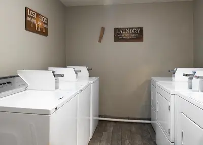 a laundry room with white washing machines and a sign on the wall at Buck Meadows Lodge in Groveland