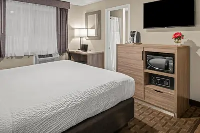 a hotel room with a bed and a flat screen tv at Buck Meadows Lodge in Groveland
