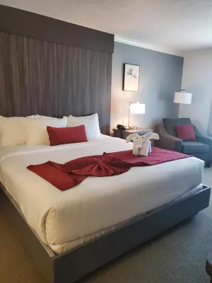 a bedroom with a large bed with a teddy bear on it at Sequoia Inn in Hanford