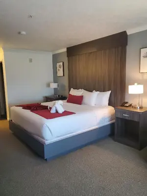 a bedroom with a large bed with a stuffed animal on it at Sequoia Inn in Hanford