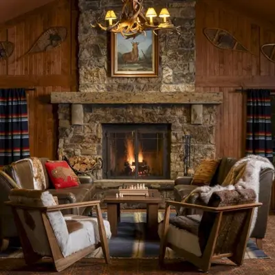 a living room with a stone fireplace and two chairs at Wayfinder Bishop in Bishop
