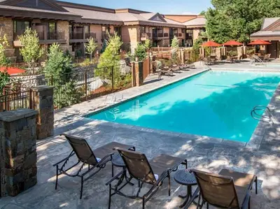 a swimming pool at a resort with chairs and a table at Wayfinder Bishop in Bishop