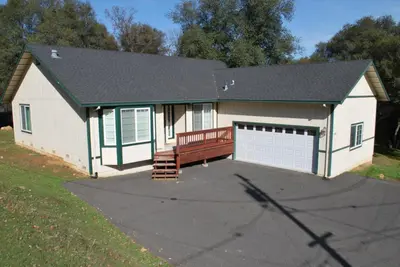 a small white garage with a bench in front of it at Big Tom's Cabin by Yosemite, lake and trails in Groveland
