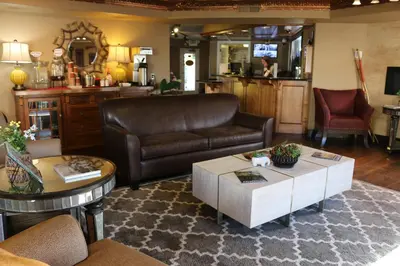 a living room with a leather couch and a coffee table at Historian Inn in Gardnerville
