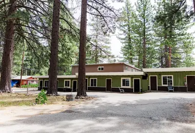a green building with trees in front of it at The Washoe Lodge in South Lake Tahoe