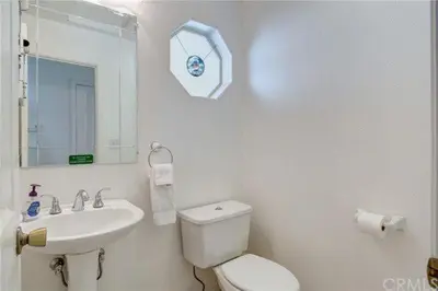 a white bathroom with a toilet and a sink at Pine Arbor Retreat in Yosemite West