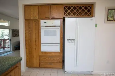 a kitchen with a white refrigerator and wooden cabinets at Pine Arbor Retreat in Yosemite West