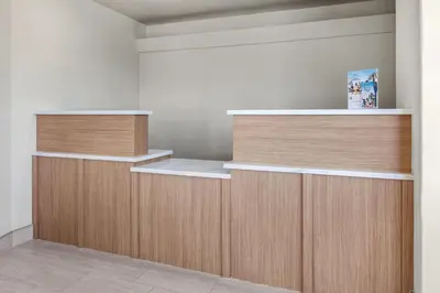 an empty room with wooden cabinets and shelves at Ramada by Wyndham Merced in Merced