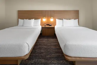 a hotel room with two beds and a desk at Ramada by Wyndham Merced in Merced