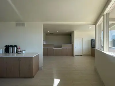 a large kitchen with a counter and a large window at Ramada by Wyndham Merced in Merced