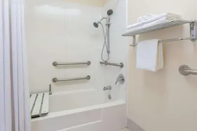 a bathroom with a shower and a tub and a toilet at Days Inn by Wyndham Modesto in Modesto