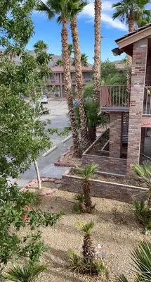 a house with palm trees next to a driveway at Death Valley Inn in Beatty