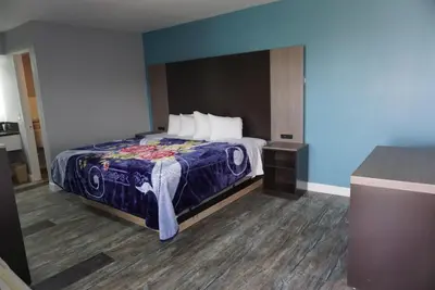a bedroom with a bed with a blue wall at Thunderbird Motel in Bishop