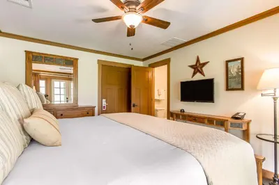 a bedroom with a white bed and a flat screen tv at Sierra Sky Ranch in Oakhurst