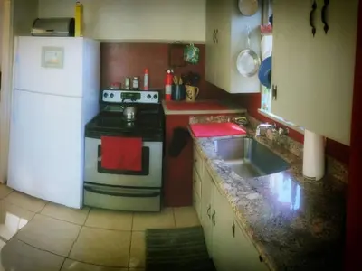 a small kitchen with a stove and a sink at Cozy Muir Cottage - In Town - Pet Friendly in Lone Pine