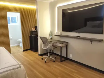a bedroom with a desk and a chair and a tv at Mountain View Motel in Bishop