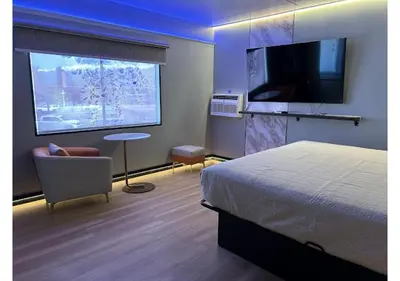 a hotel room with a bed and a large window at Mountain View Motel in Bishop