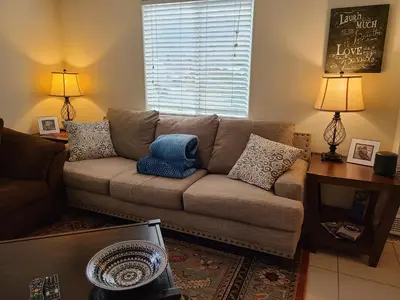 a living room with a brown couch with pillows at Sacred Mtn River Suites in Kernville