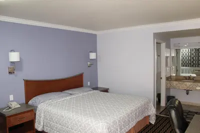 a hotel room with a bed and a bathroom at Trails Motel in Lone Pine