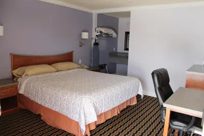 a hotel room with a bed and a desk and a chair at Trails Motel in Lone Pine