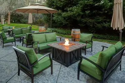 a patio with chairs and a table with a fire pit at Lake Natoma Inn in Folsom