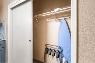 a closet with a blue shower curtain and a mirror at Country Inn Sonora in Sonora