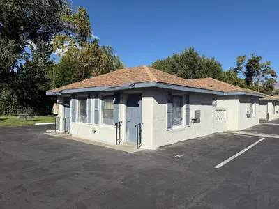 a white building in a parking lot at Bishop Elms Motel in Bishop
