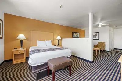 a hotel room with a bed and a chair at Best Western Plus Executive Inn & Suites in Manteca