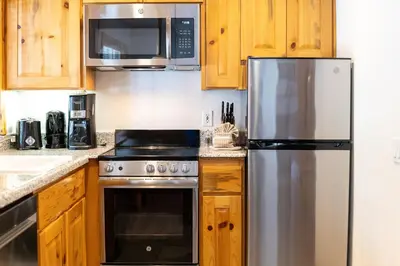 a kitchen with wooden cabinets and a stainless steel refrigerator at Red Wolf Lakeside Lodge in Tahoe Vista