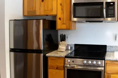 a kitchen with a stainless steel refrigerator and a microwave at Red Wolf Lakeside Lodge in Tahoe Vista